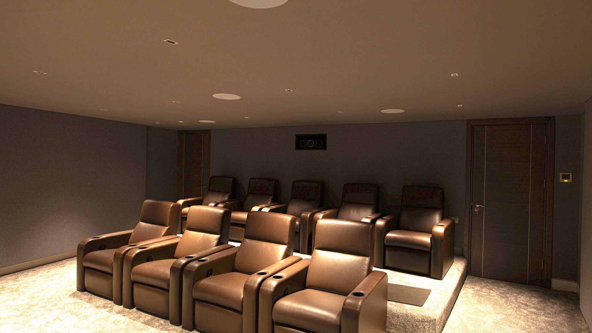 View to rear of immersive home cinema, shows Fortress seating and Barco projector.
