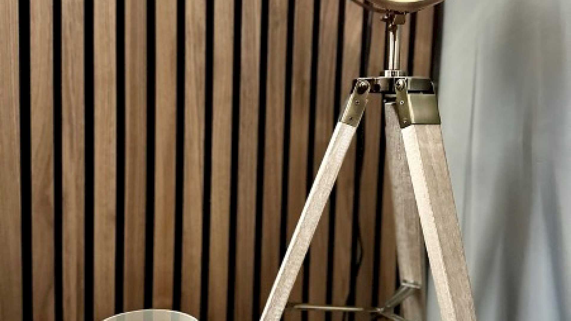 Image shows table lamp with candle, against an acoustic panel background.