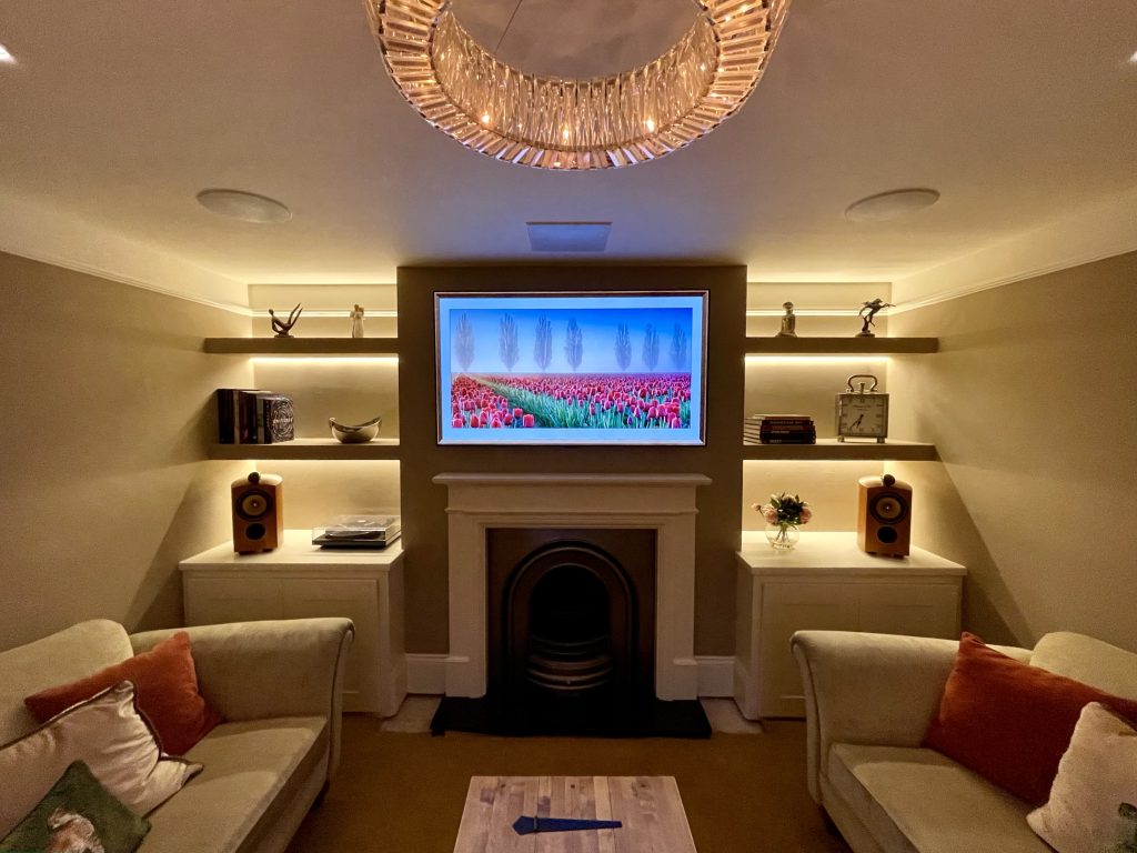 Lutron lighting in home cinema media room, with TV above fireplace and in ceiling speakers