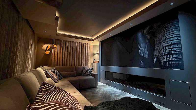 Home technology in Surrey - media room with led lighting, motorised curtains, projector and screen.