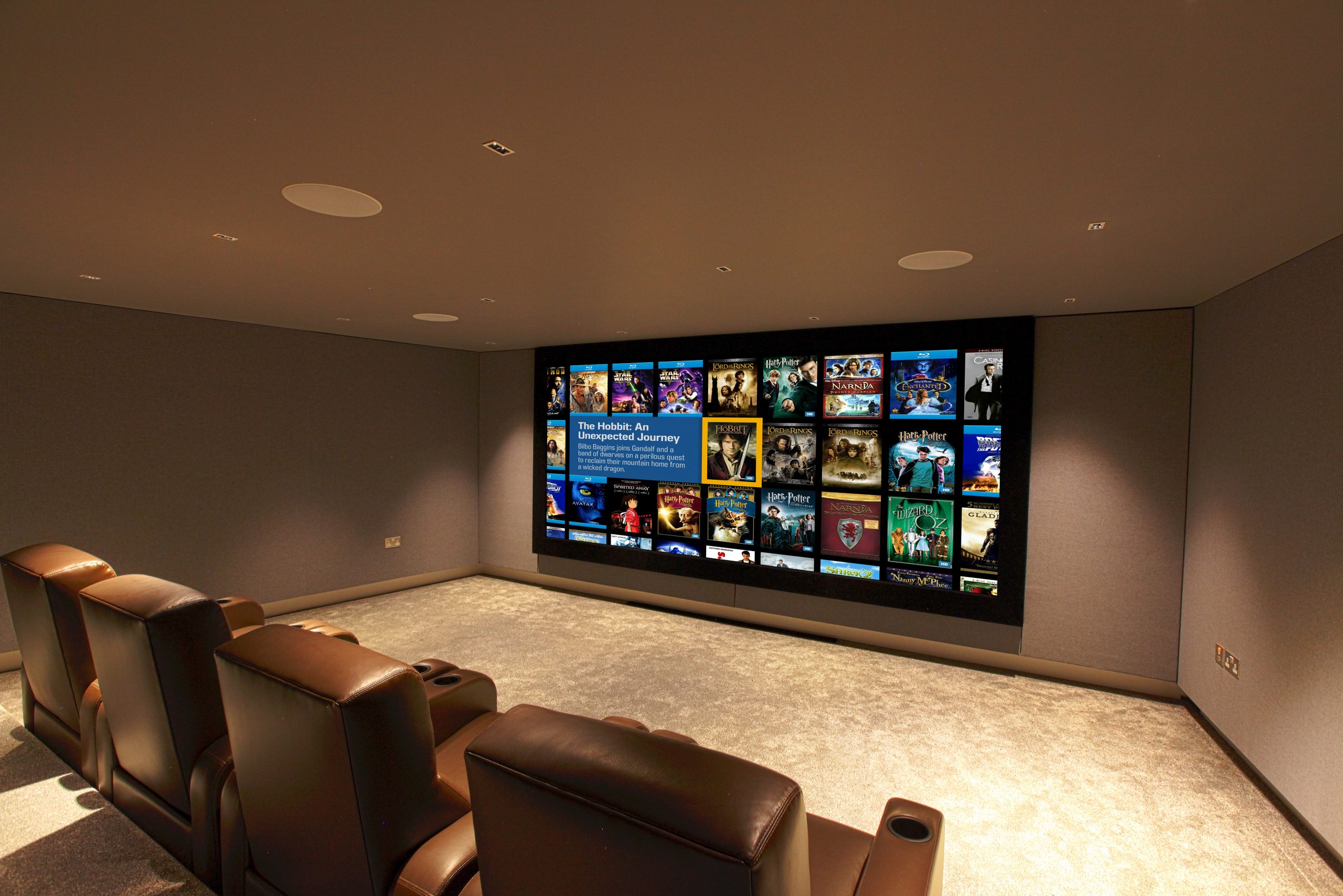 Immersive home cinema, looking at screen from rear right. Shows Fortress seating and Kaleidescape image.