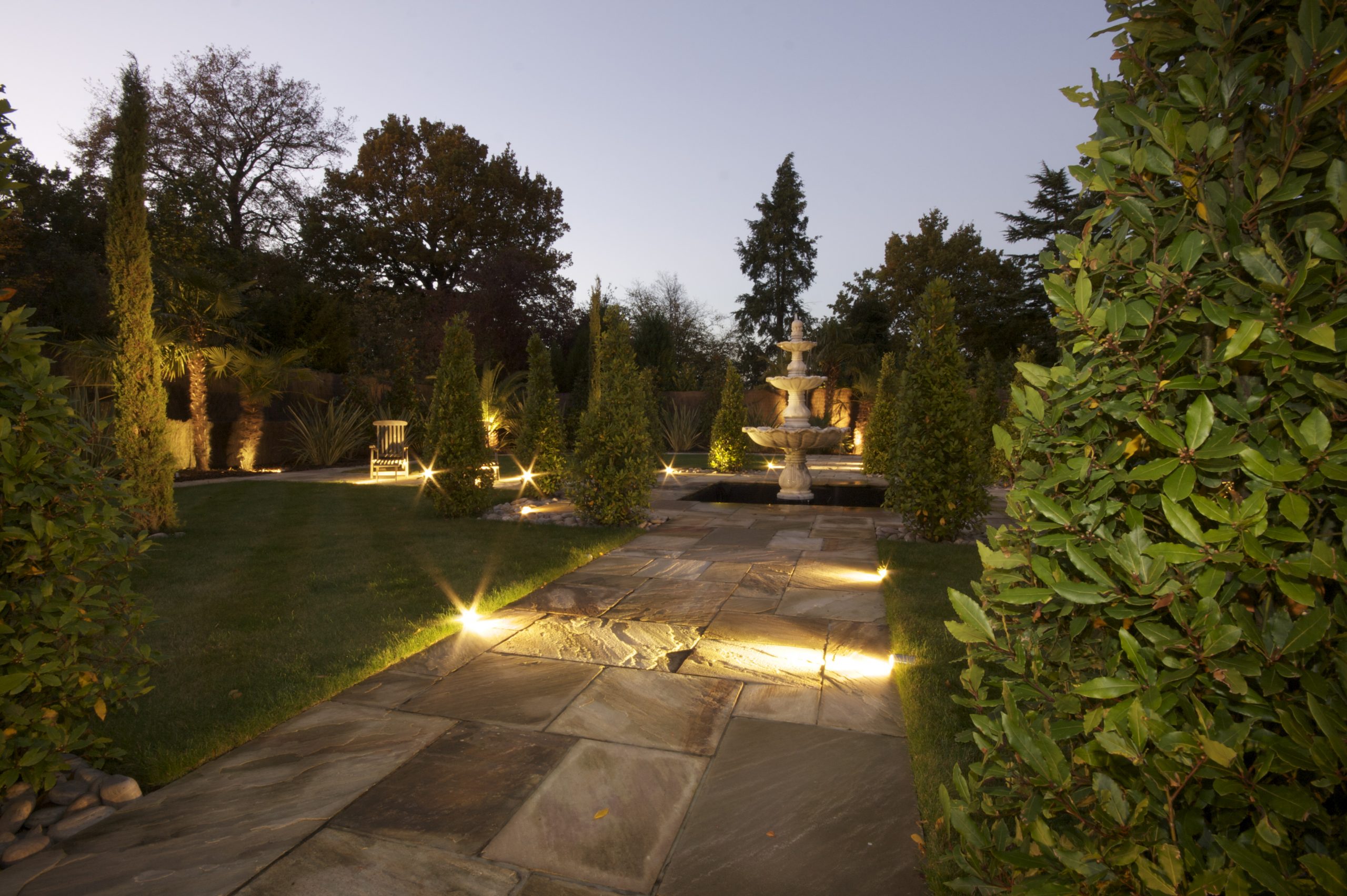 Garden with outside lighting, low level lights and accent light on fountain.