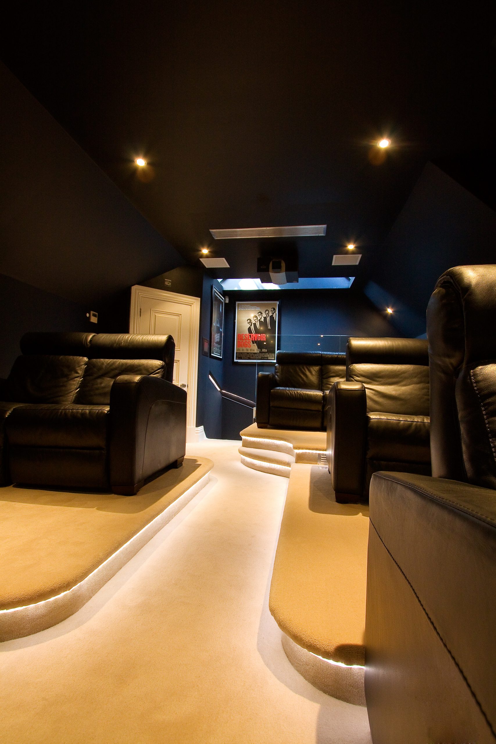 Image shows rear of home cinema with projector mounted on ceiling.