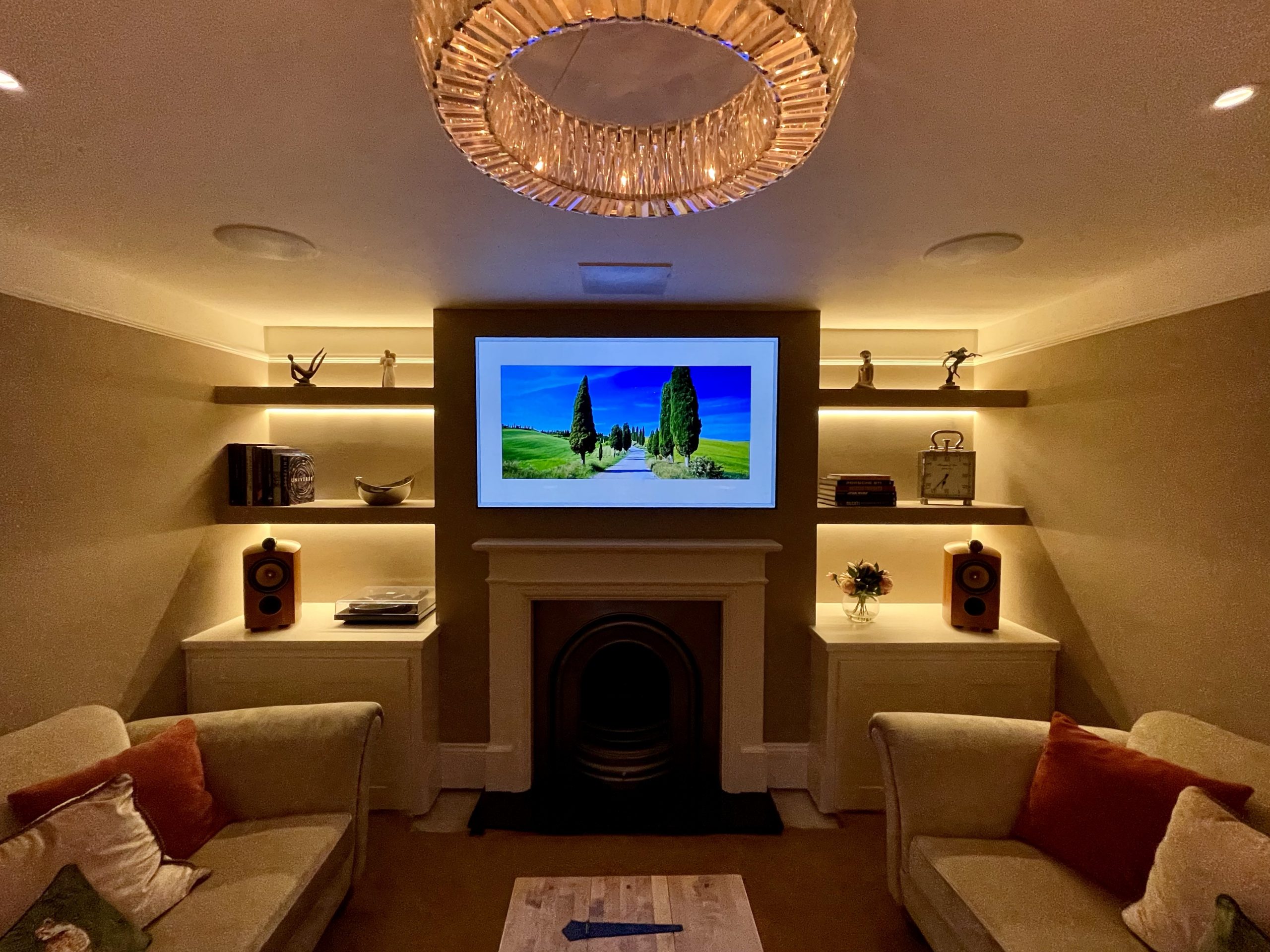 Lutron lighting in home cinema media room, with TV above fireplace and in ceiling speakers