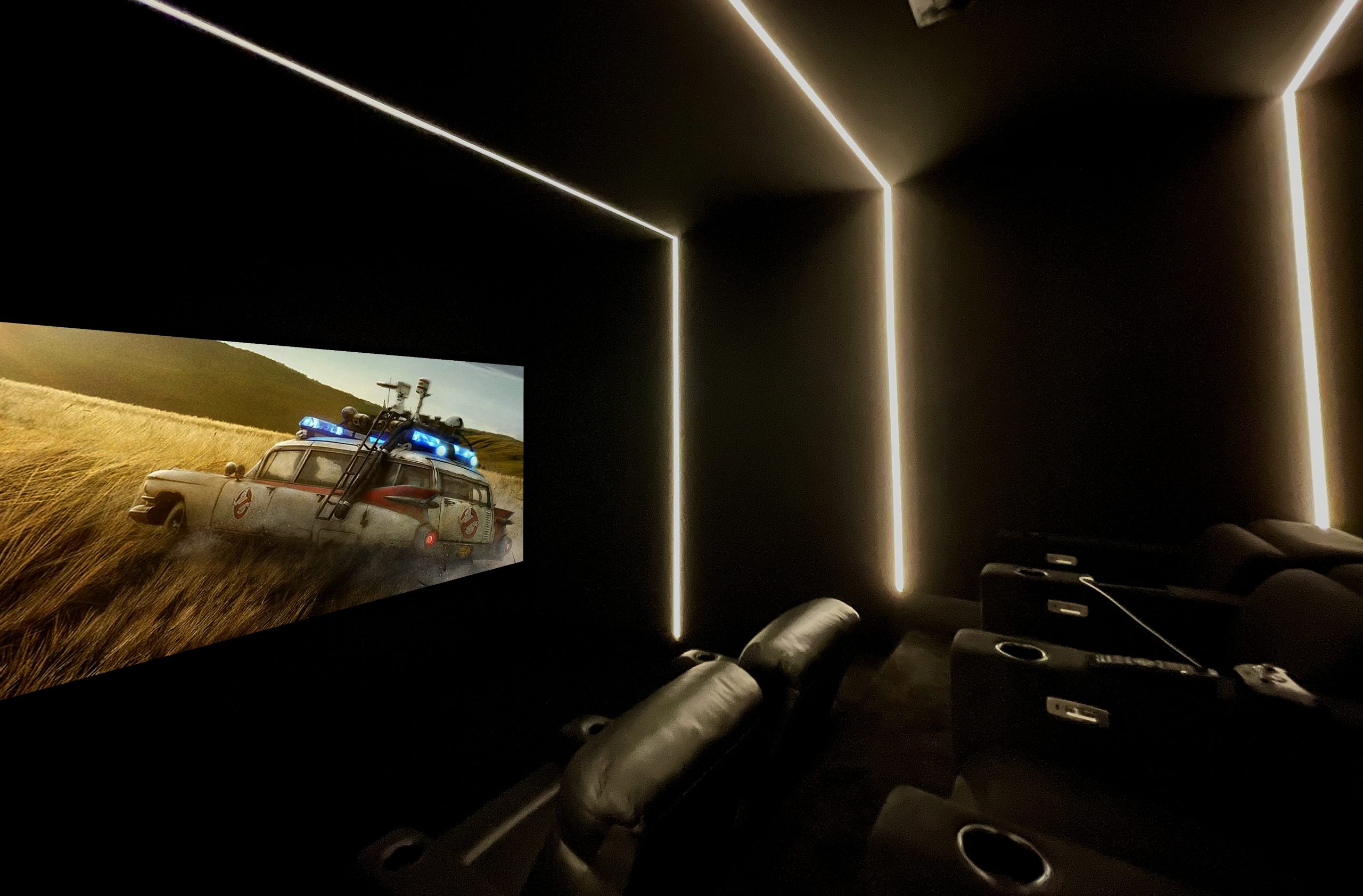 Home cinema with lighting, seating and a film playing.